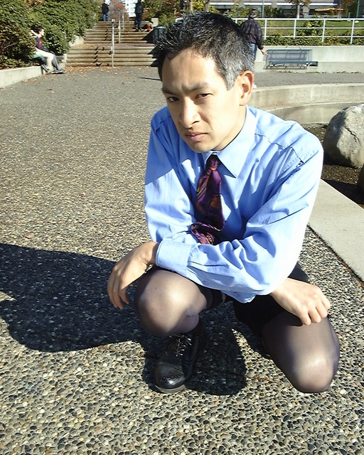 a man sitting on the ground with his feet crossed, with both of his legs folded