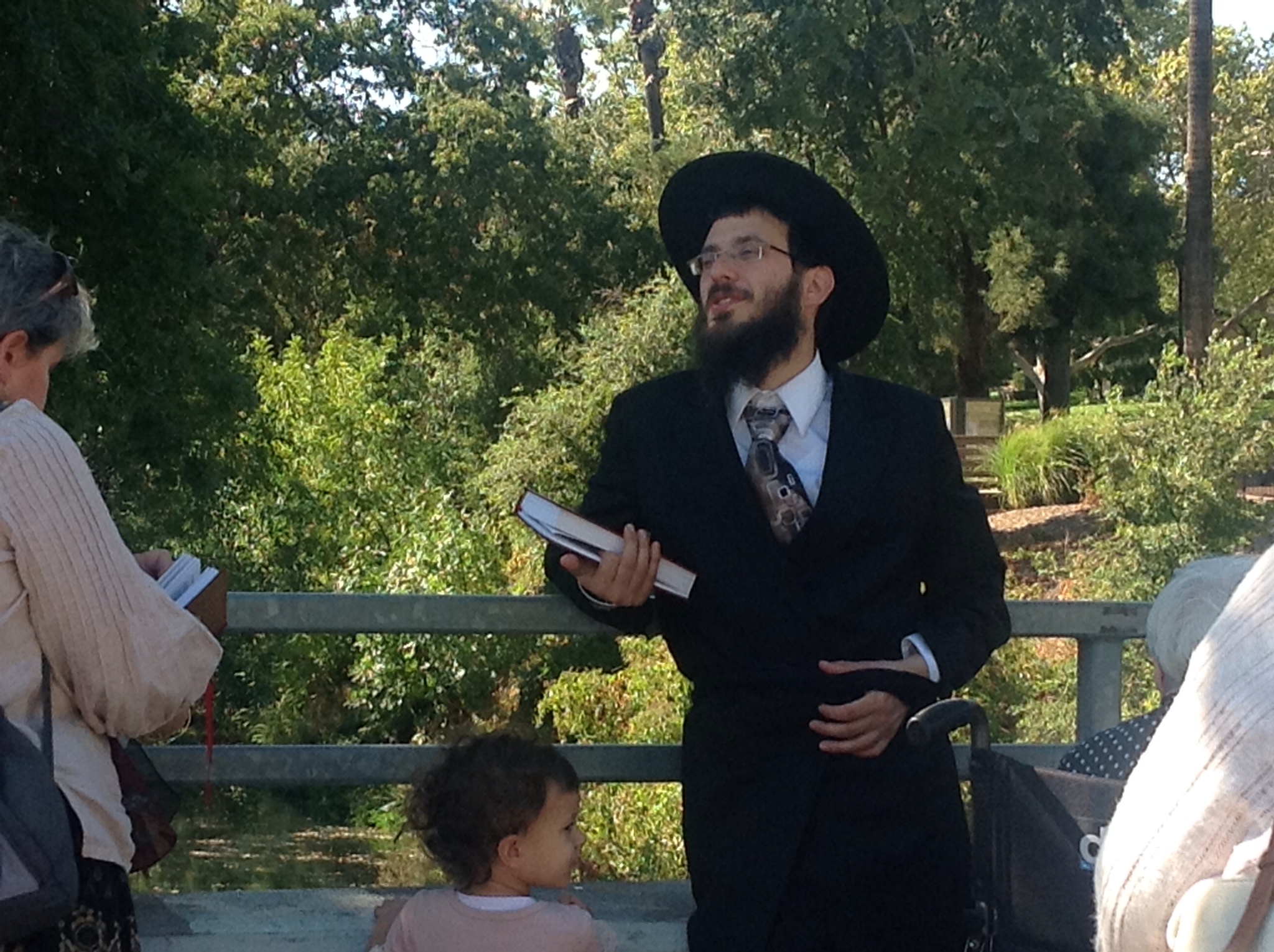 a man dressed as rabbi khatar reading the koran scroll