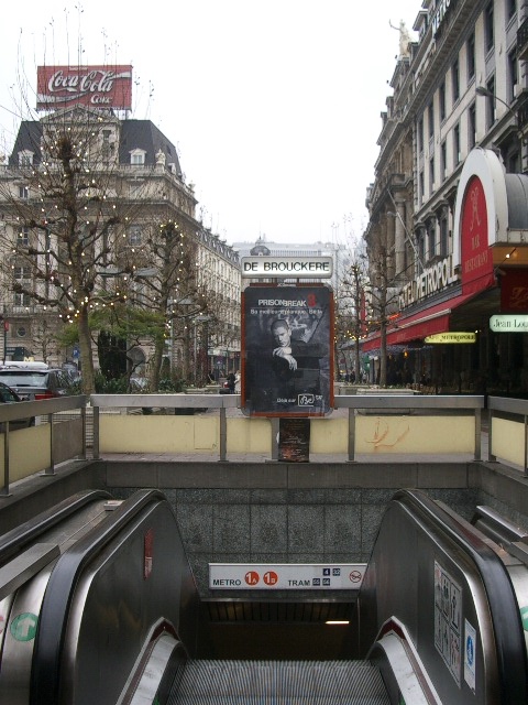 an escalator that has a movie poster at the top