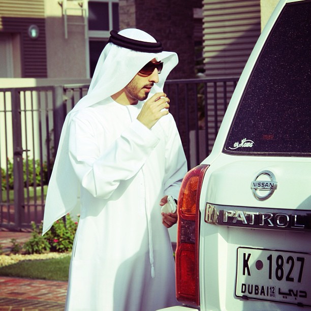 a man dressed as a nun is standing in front of a car