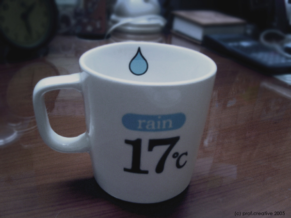 a mug with a water drop inside sits on a table