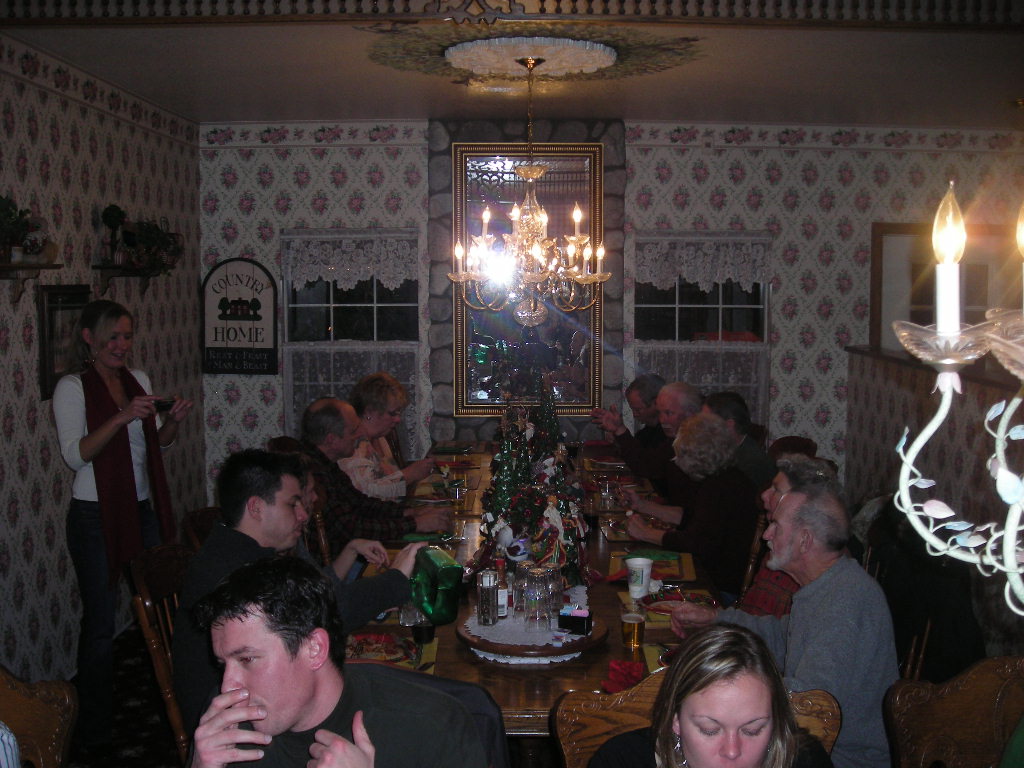 several people gathered at the table enjoying a meal