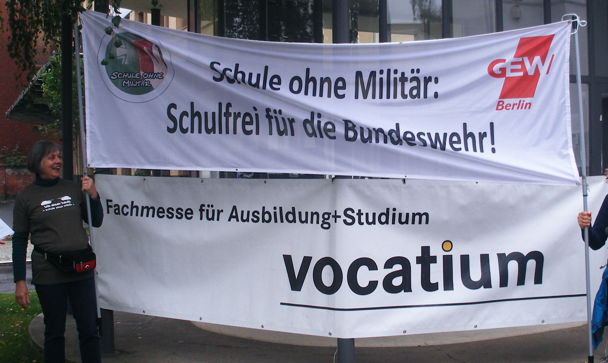 a sign in the center of two men standing under a banner