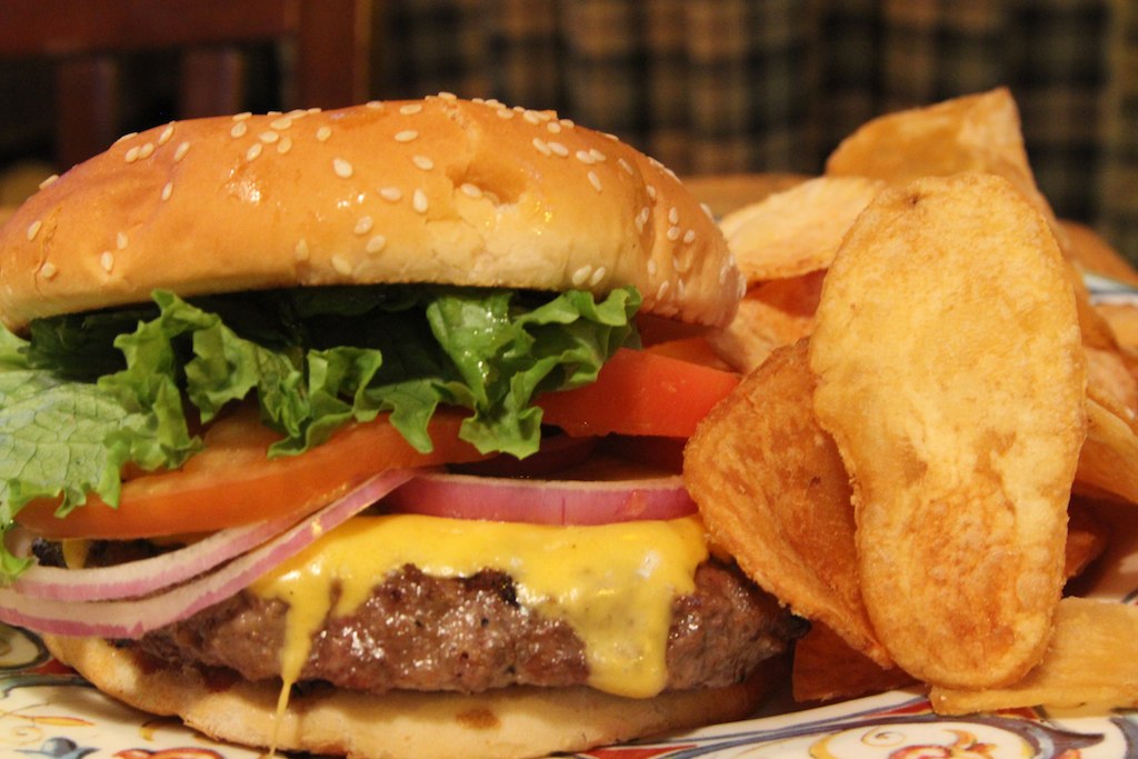 a burger, french fries and some tomatoes are on a plate