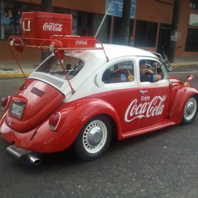 this old - fashioned car is parked outside of a coke building