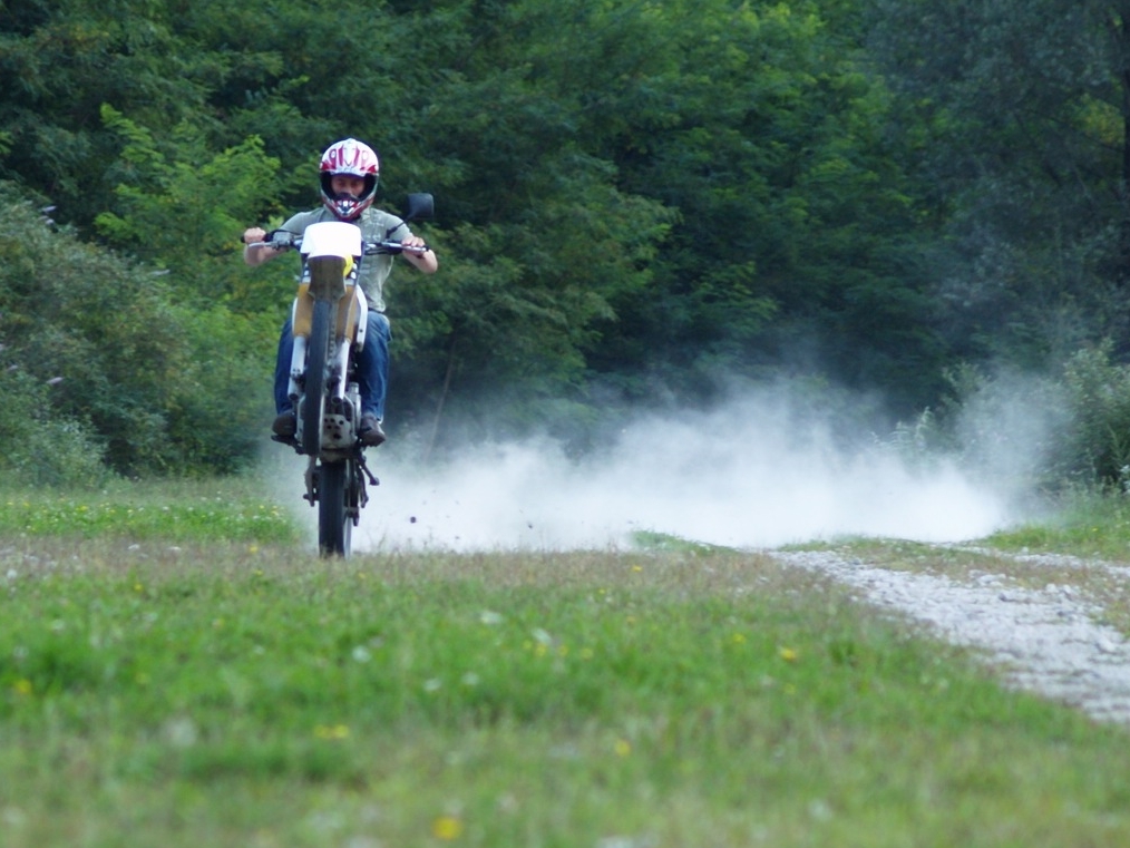 the motorcyclist is riding on his dirt bike down a trail