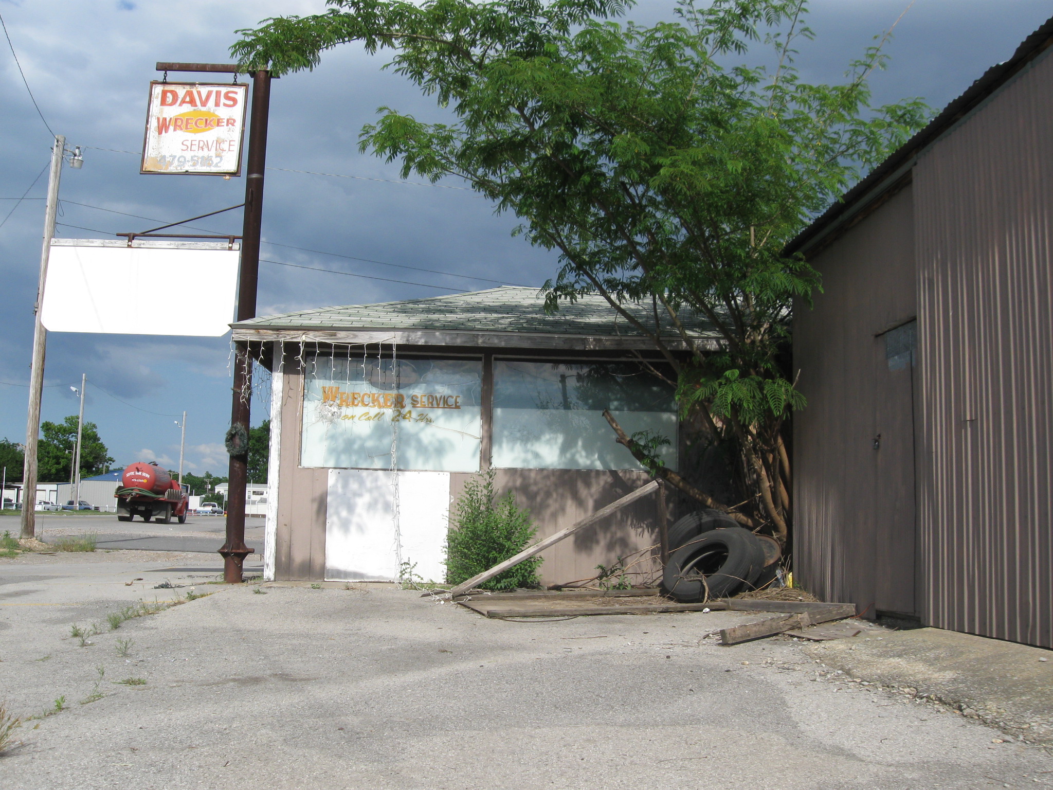 a dilapidated car garage sitting next to an old building