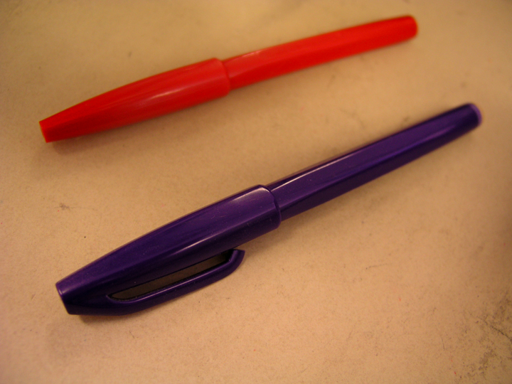 a closeup of two pens on a white counter