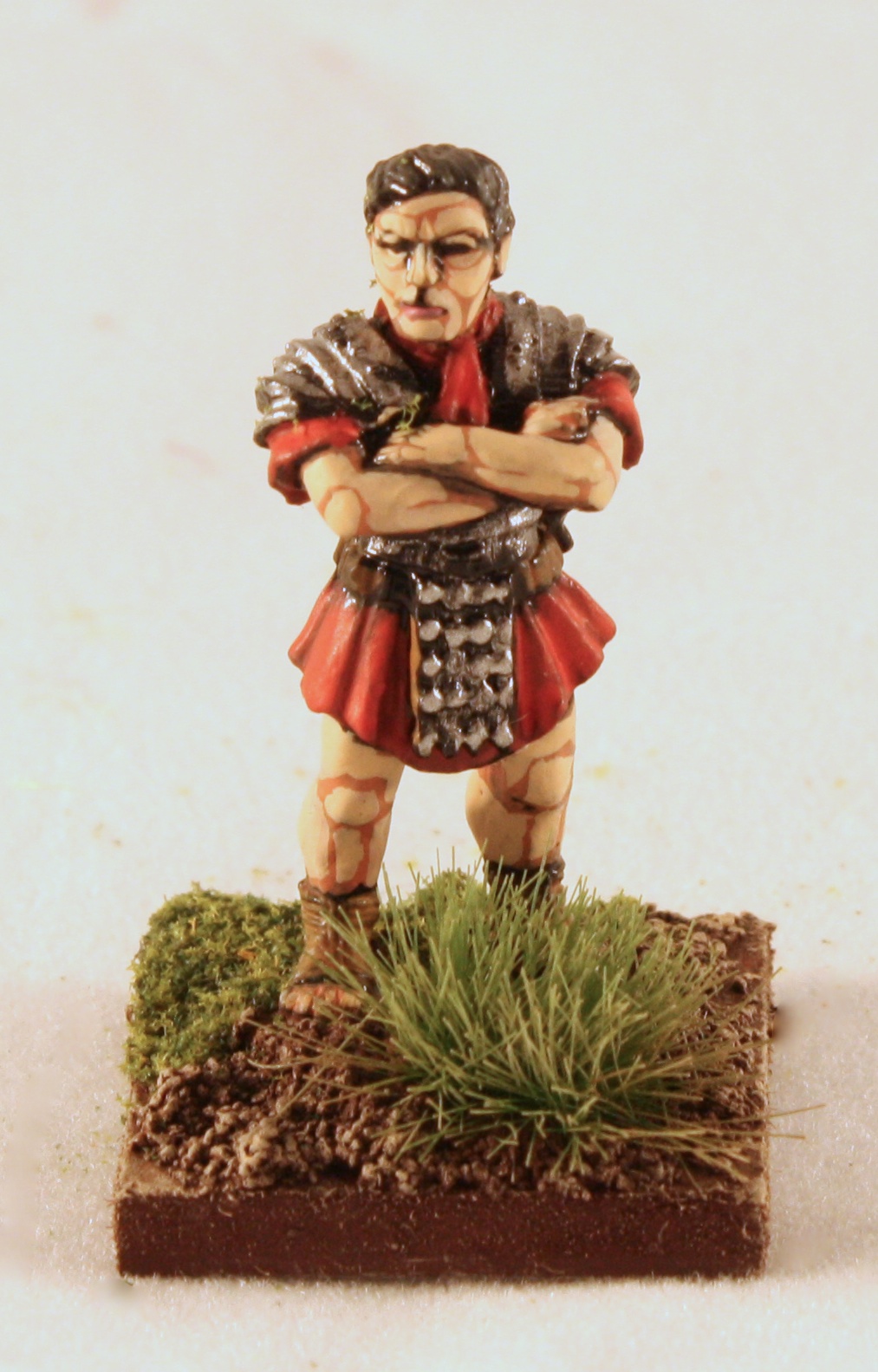 a plastic figurine in armor standing on top of grass