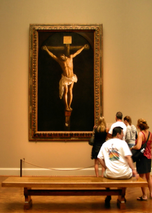 people standing in front of a painting of jesus on a cross