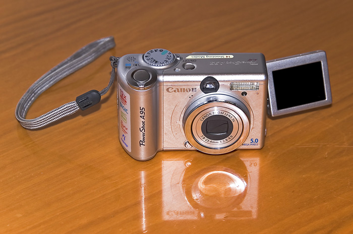a silver camera sitting on a brown table
