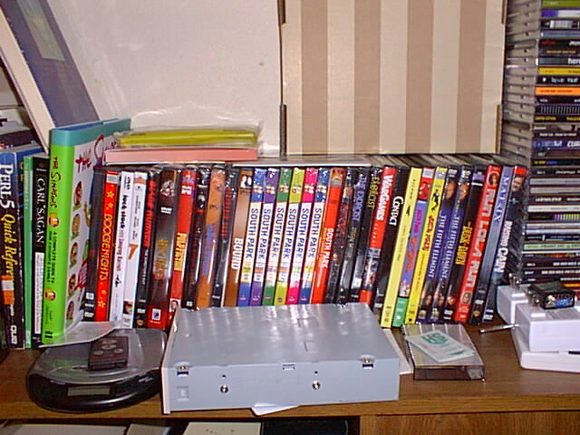 many dvds are on a desk with a remote