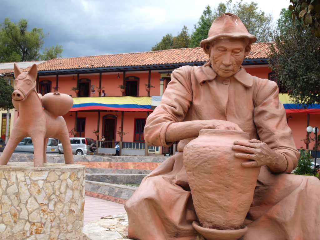 a small sculpture of an elderly man next to a pig