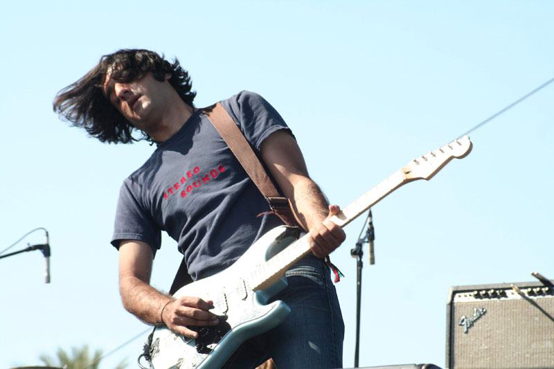 a man plays a guitar with long hair