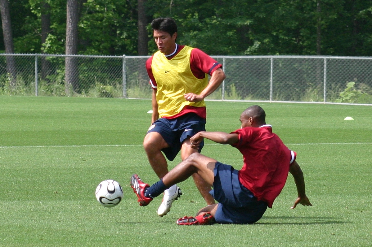 two men in uniforms playing soccer on a field