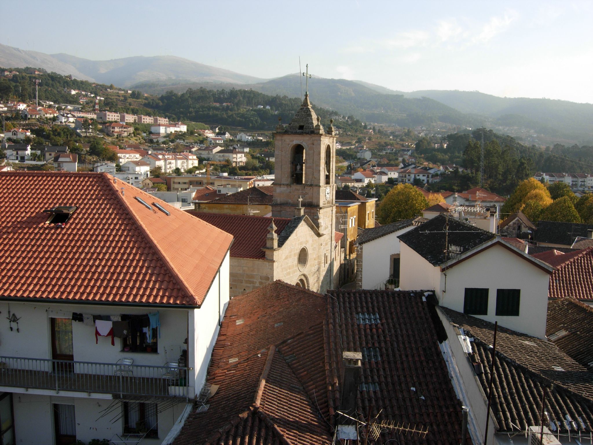 a small village that has some rooftops with a clock on it