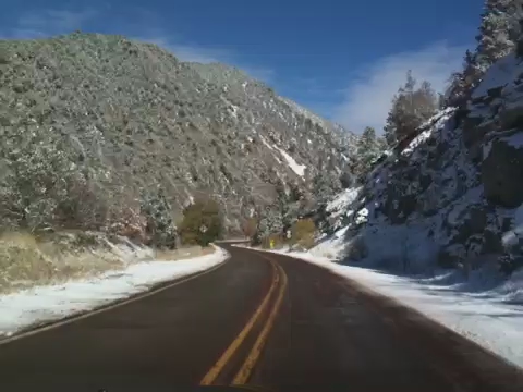 a view from the front seat of a car driving on a snowy road