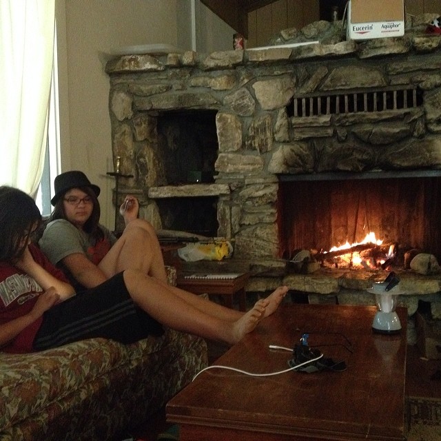 people are sitting on their own sofa near the fire place