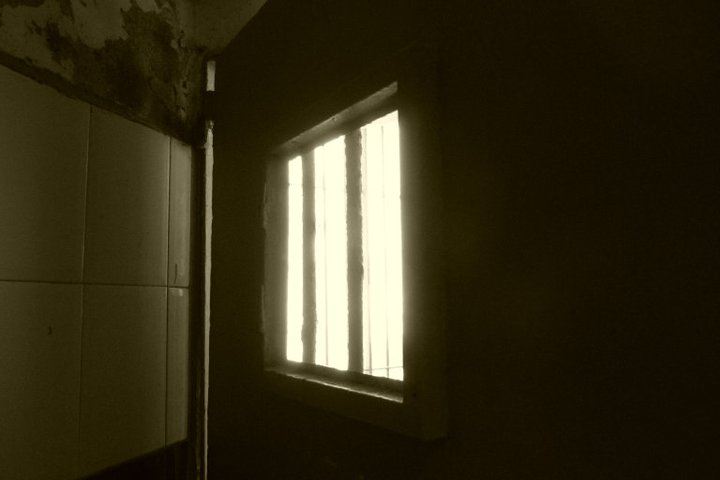 a dirty bathroom area with a light coming in the window
