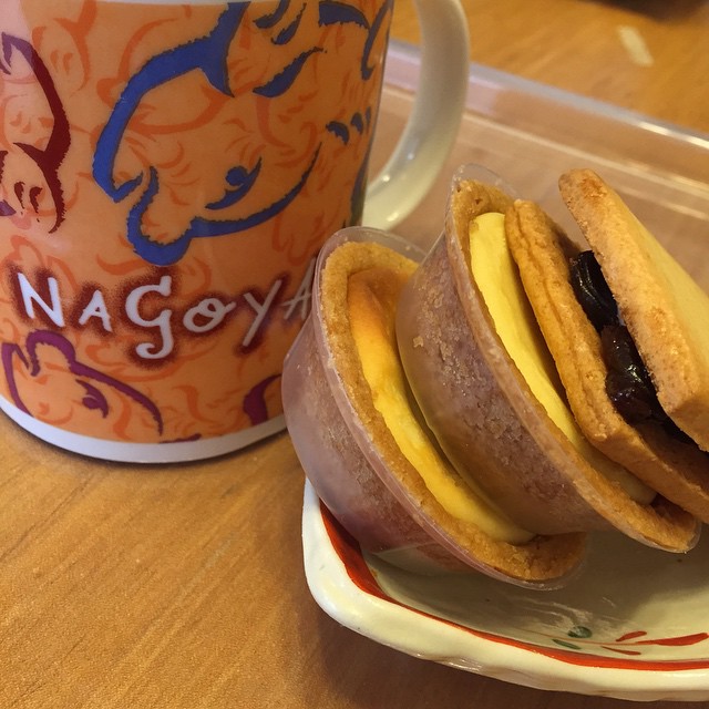 a cup of coffee and cookies with jam on top