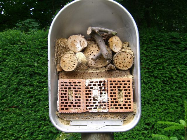 an overhanging mailbox with various pieces of wood piled together