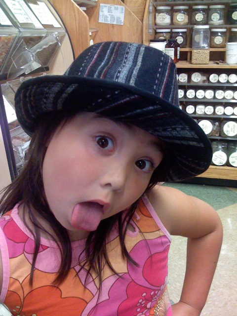 a child wearing a hat sticking his tongue out