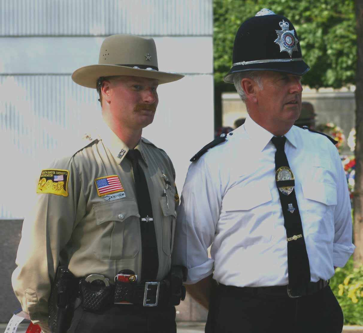 two uniformed men standing in a courtyard next to each other