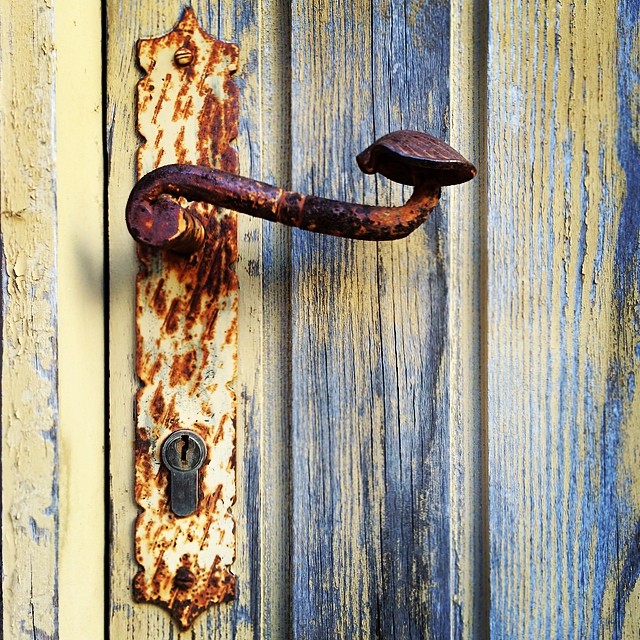 an old door handle on a rusted metal latch