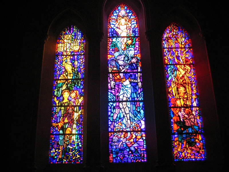 a group of three stained glass windows inside of a church