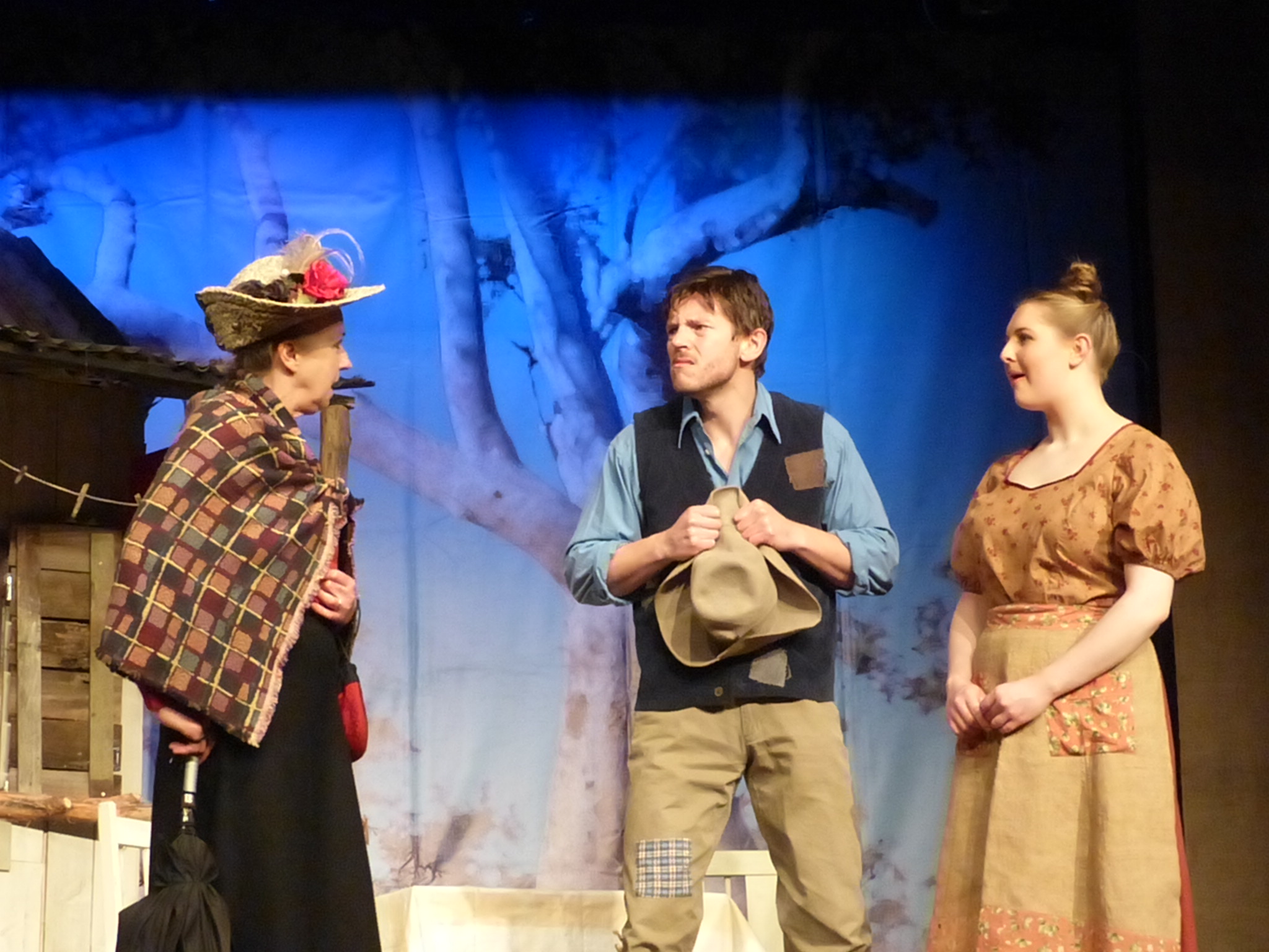 three people on stage are dressed up for play