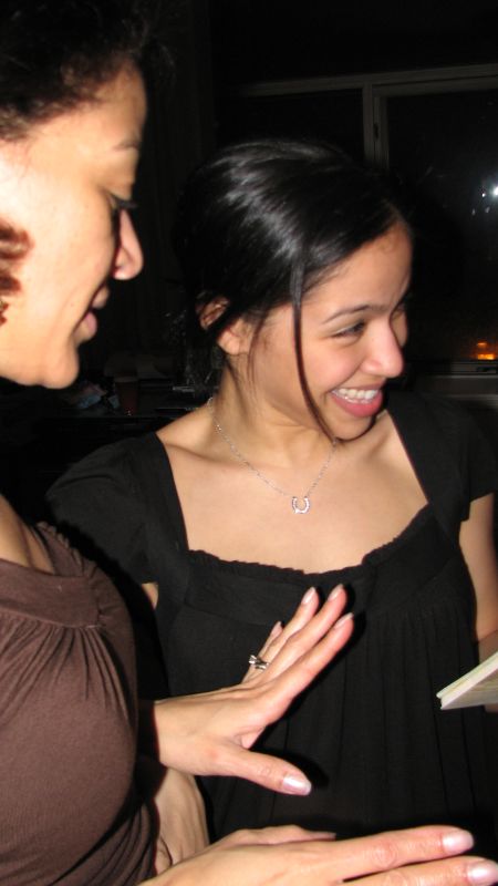 two women smile and laugh together with one holding her finger out