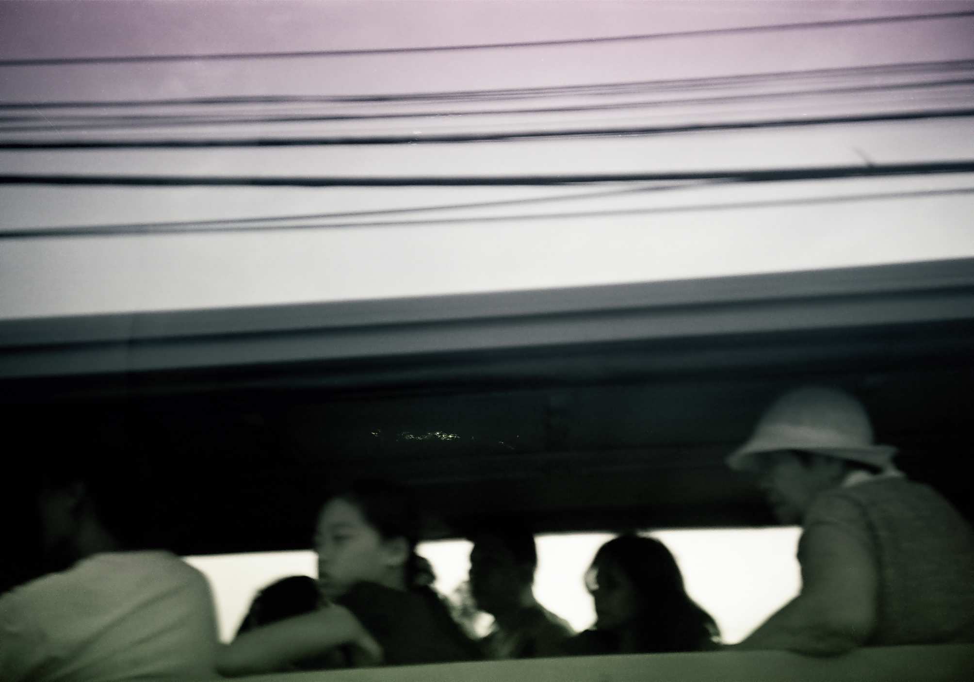 four people are in a bus looking out the window