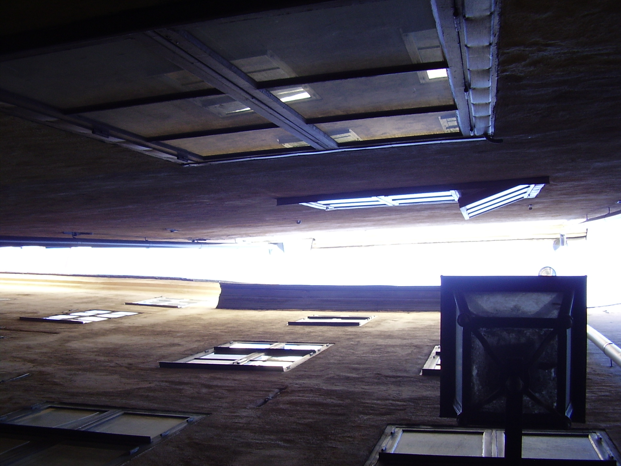 sunlight coming through an otherwise empty roof with concrete floors