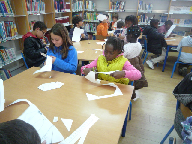 a group of children working on some white paper