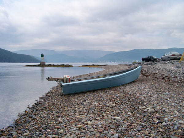 the blue canoe lies on its side near the shore