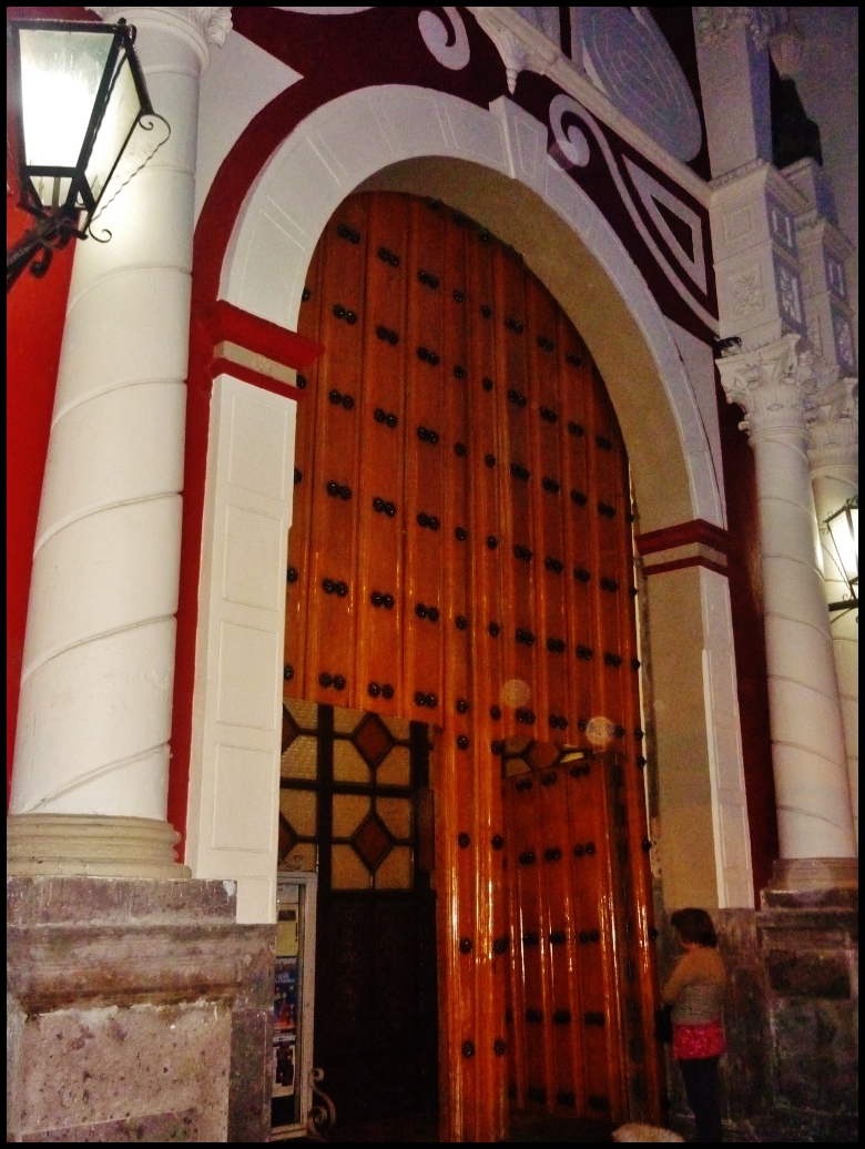 a tall door sitting inside of an ornate building