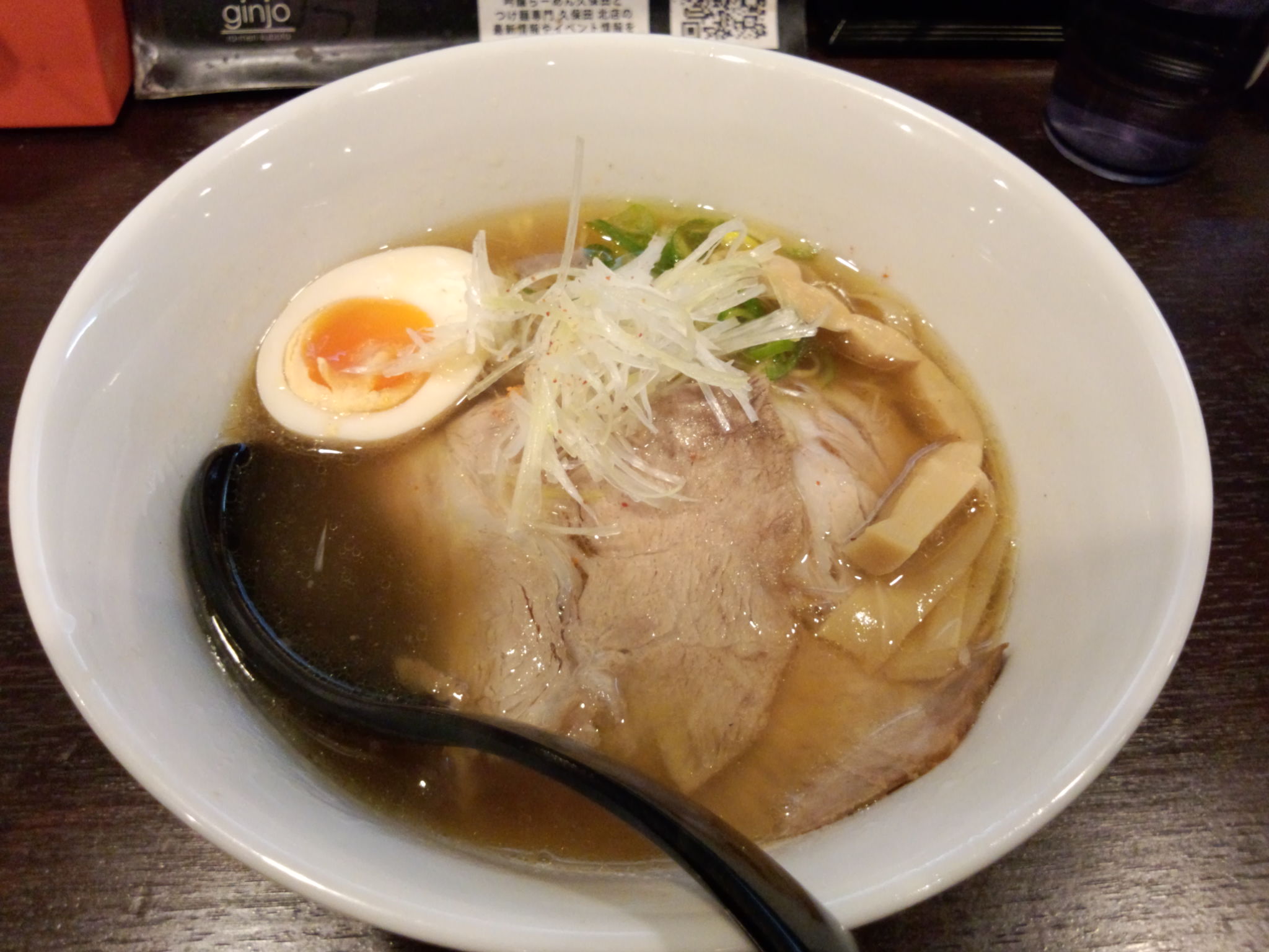 a bowl of soup with meat, rice and soft boiled egg