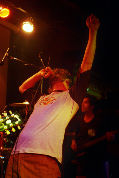 a person on a stage with his hands up and another hand raised in the air