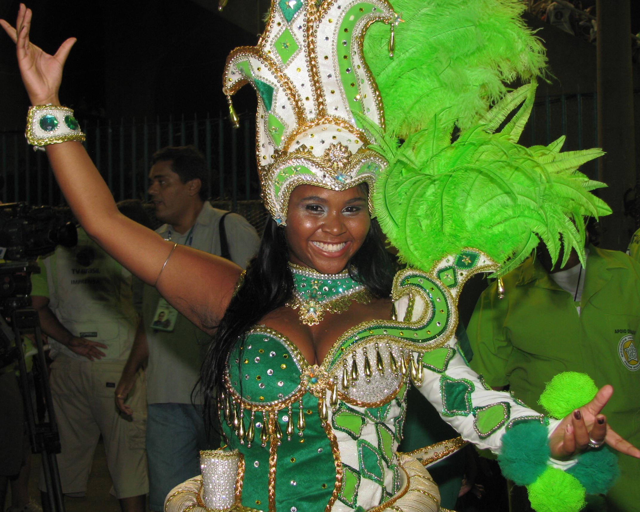 a woman in a carnival costume, waving and making peace