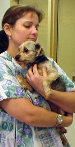 a woman holding her dog with both of the hands