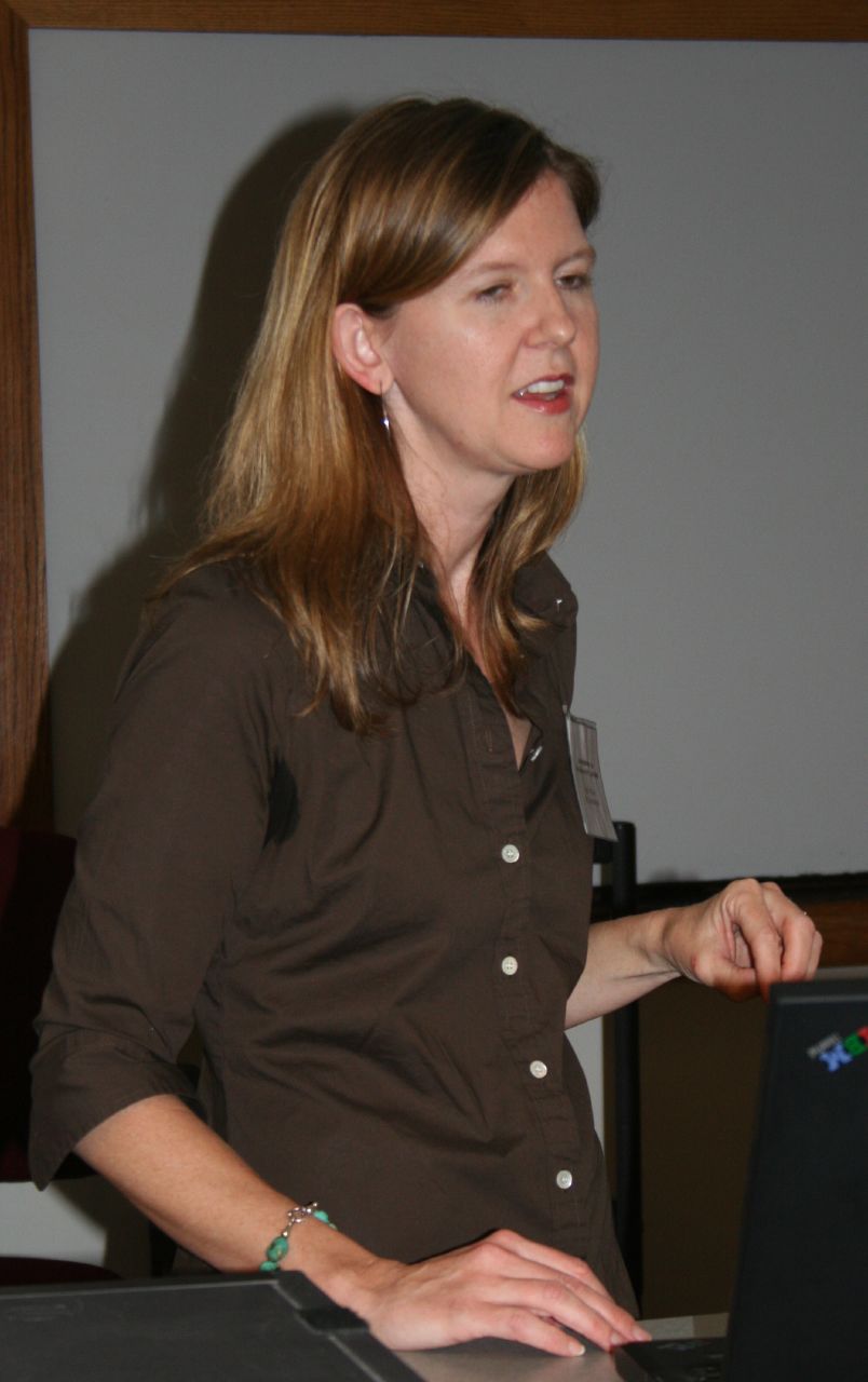 a woman standing with her hands on a laptop
