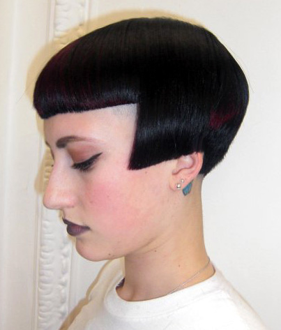 a lady with black hair and a shaved mohawk