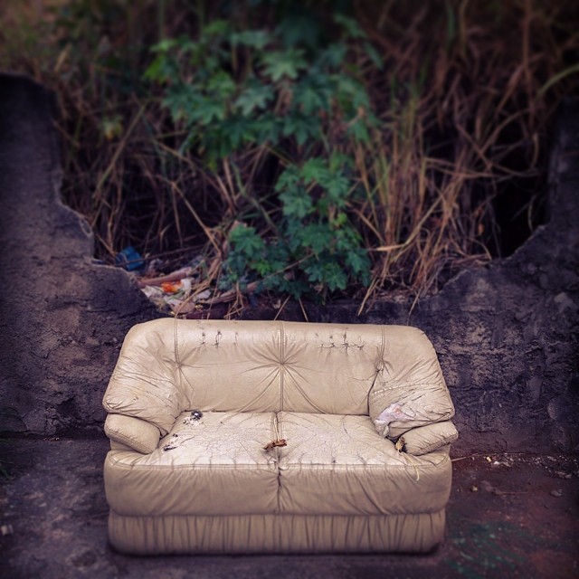 an old couch is sitting out on the ground
