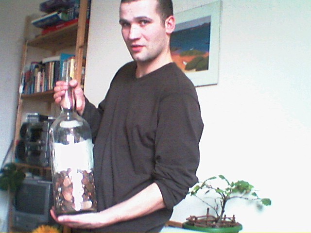 man with large bottle holding container in house
