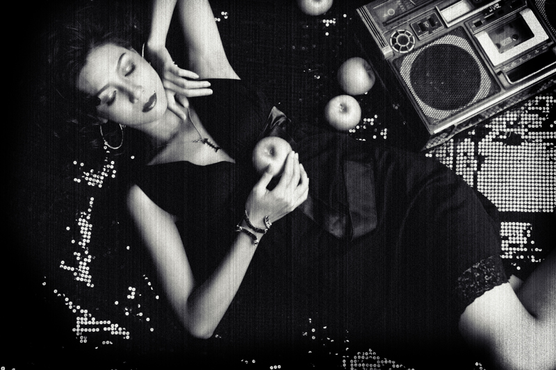 a woman laying next to a radio with an apple on her left side