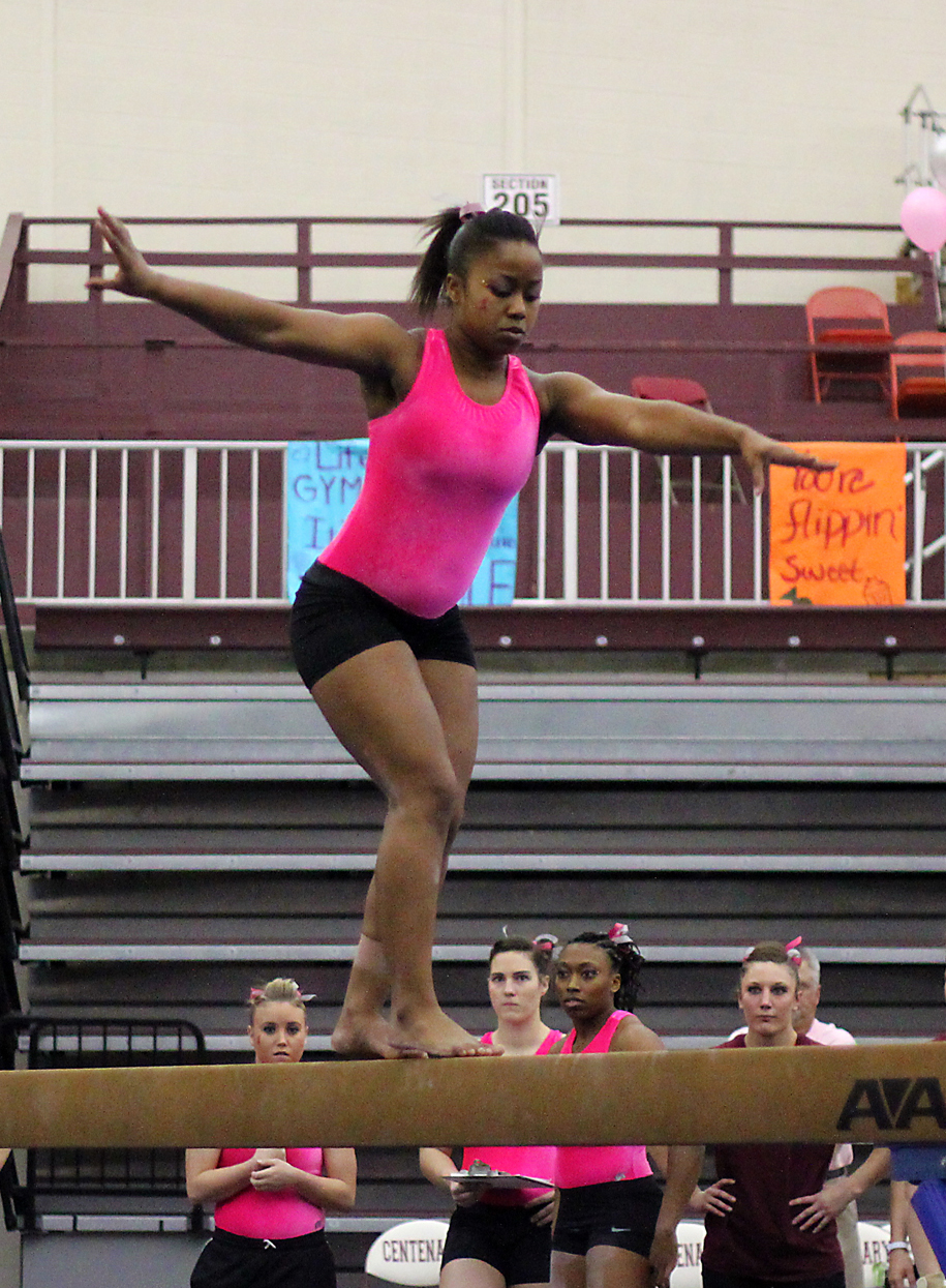 the woman is dancing on the gymnastics balance beam