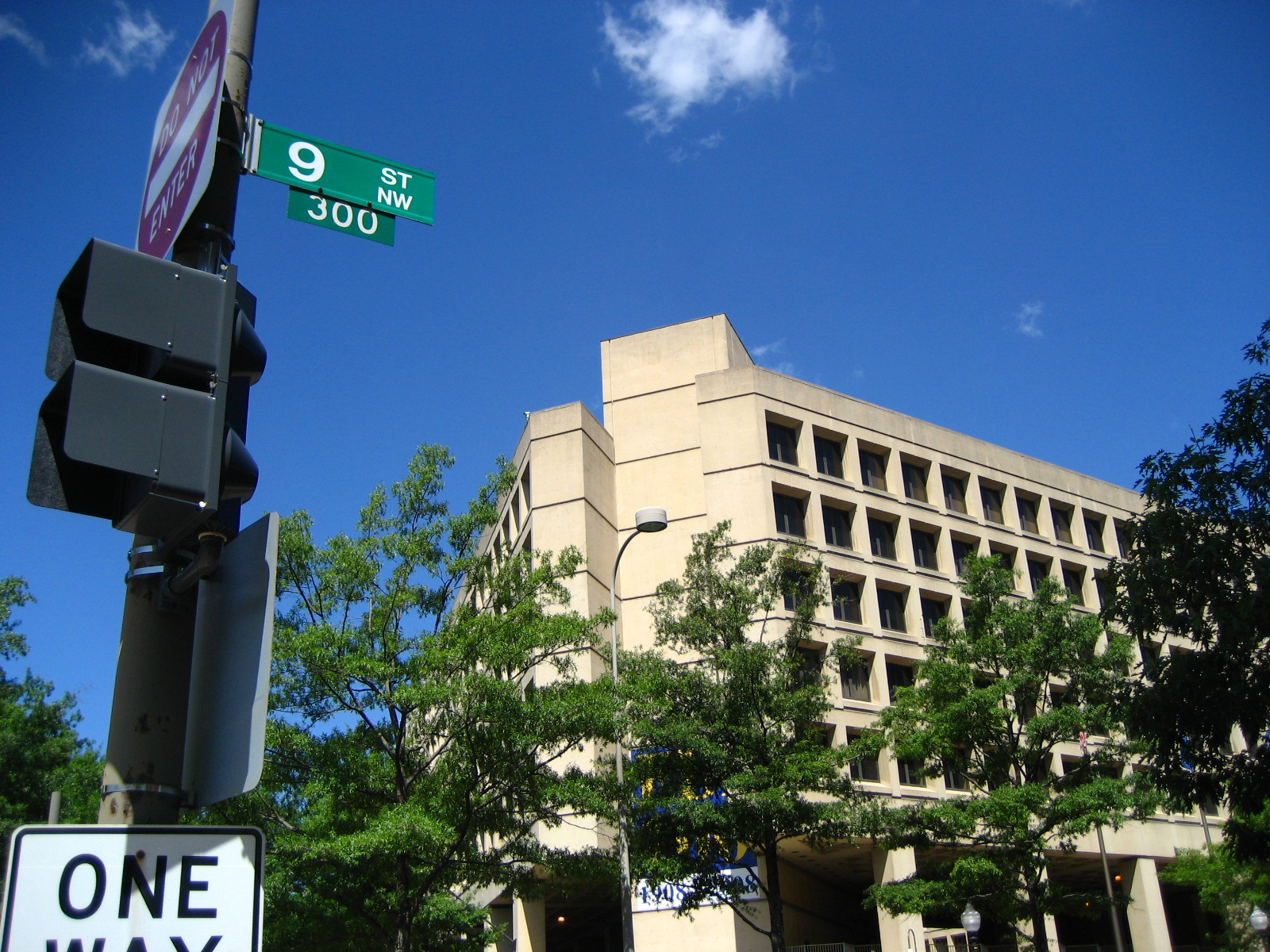 a street light and one way signs at an intersection