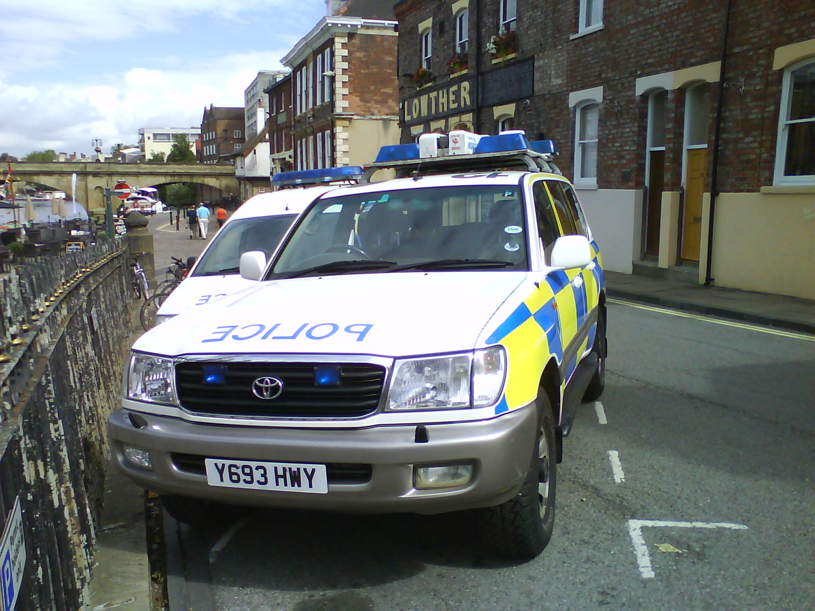 a police car parked in the street with other cars and buildings