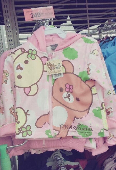 a small child's clothing rack with clothes on the rack and a teddy bear shirt