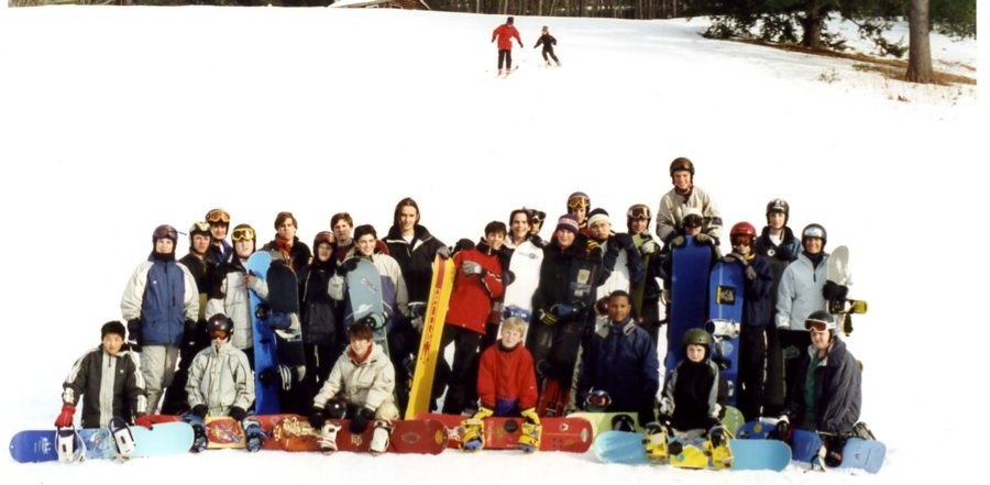 the group is posing with their snow boards on a snowy mountain